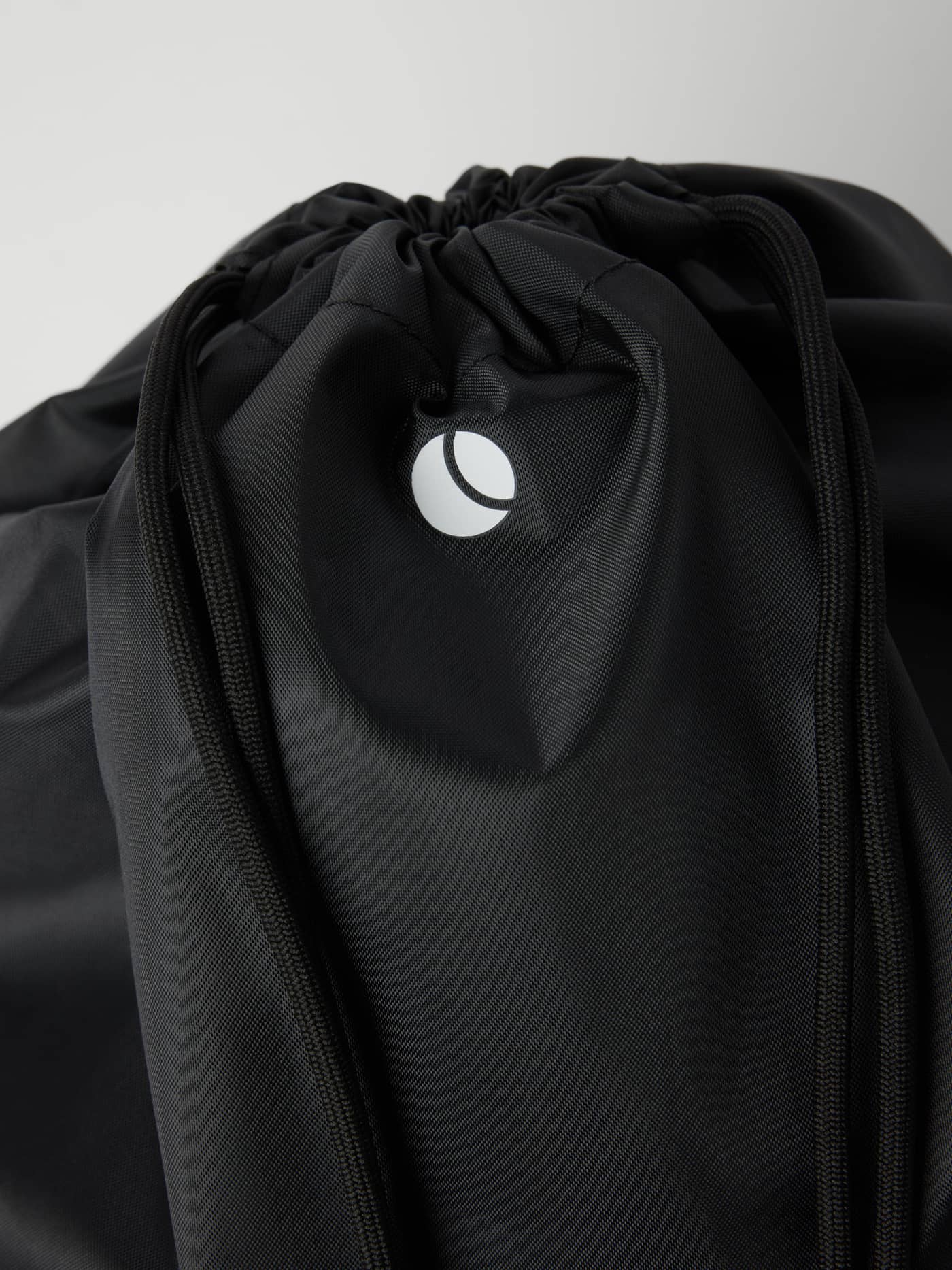 Close-up of the Black Beauty (Black) Borg Junior Drawstring Bag 15L for kids with white logo and recycled polyester. - Image 2