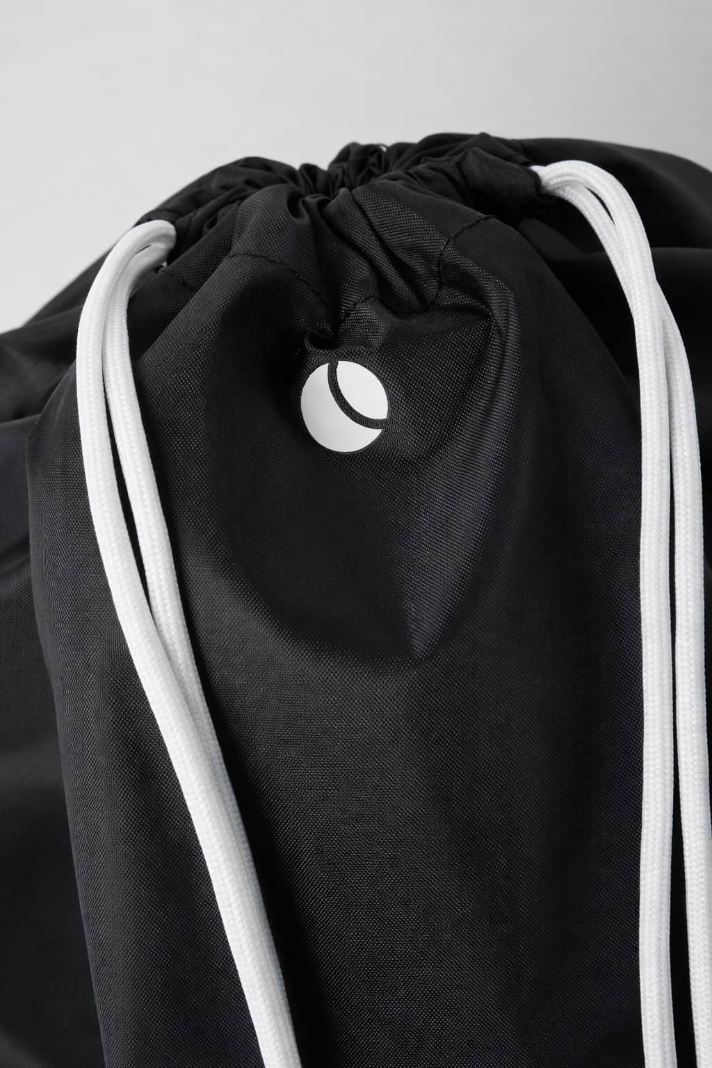 Vue en gros plan du Borg Drawstring Bag 15L pour kids en Black Beauty (Noir) en polyester recyclé avec logo blanc. - Image 2