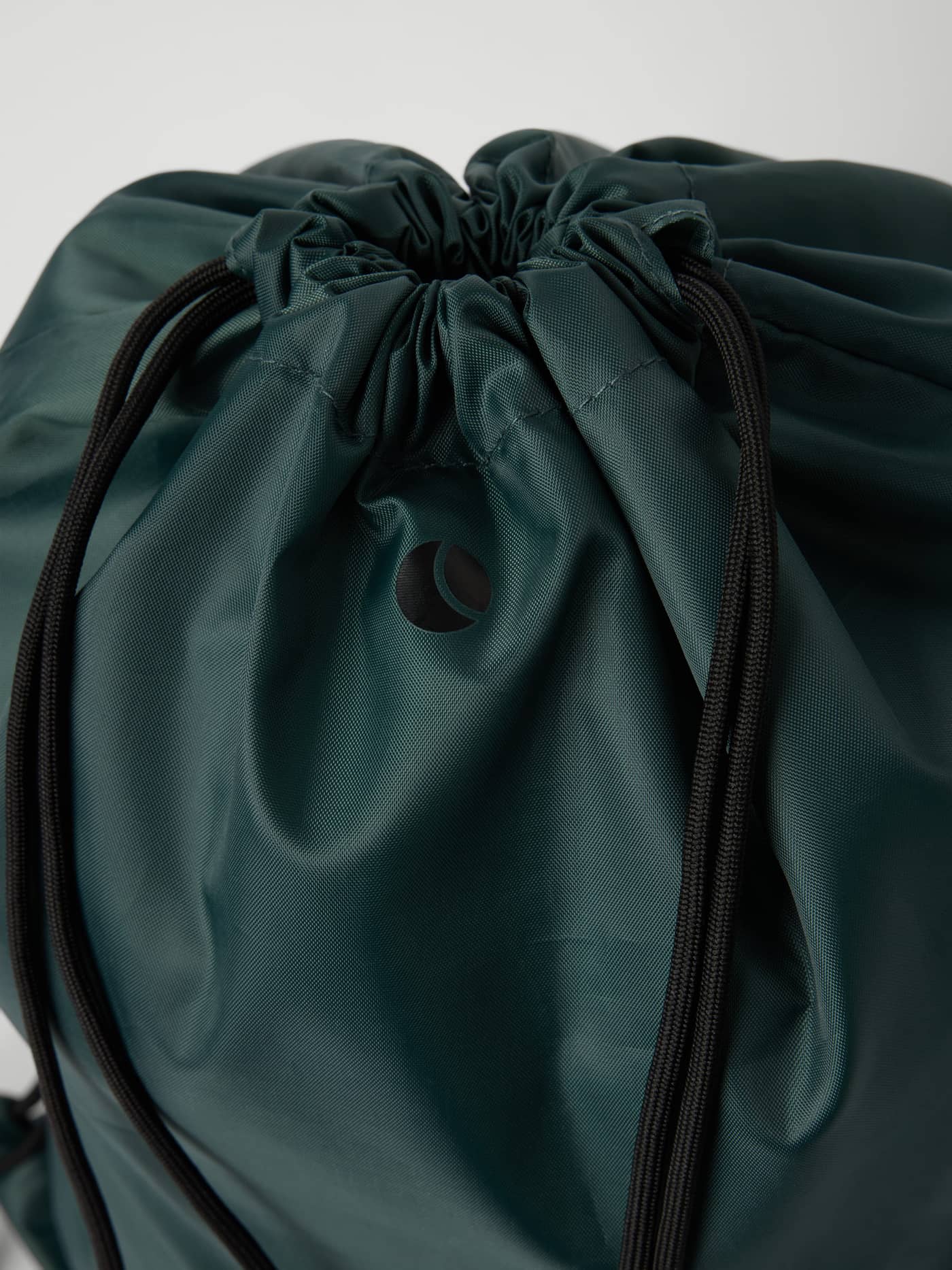 Gros plan du Borg Kids Drawstring Bag 15L en Mallard Green (Vert) avec logo noir et fermeture à cordon. - Image 2