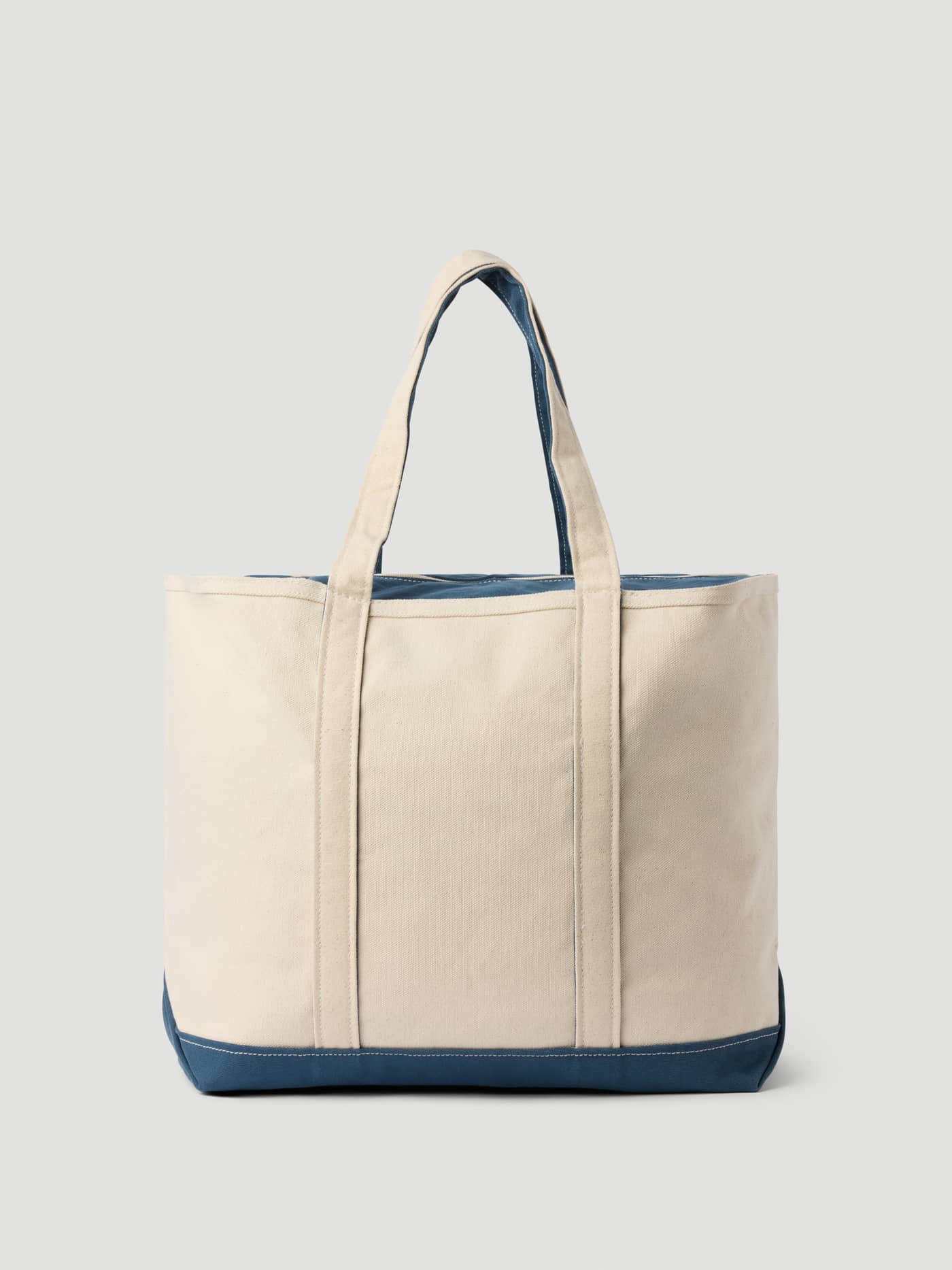 Front view of the Ace Canvas Tote 30L in Egret (White) with navy accents, crafted from 100% cotton for tennis performance. - Image 2