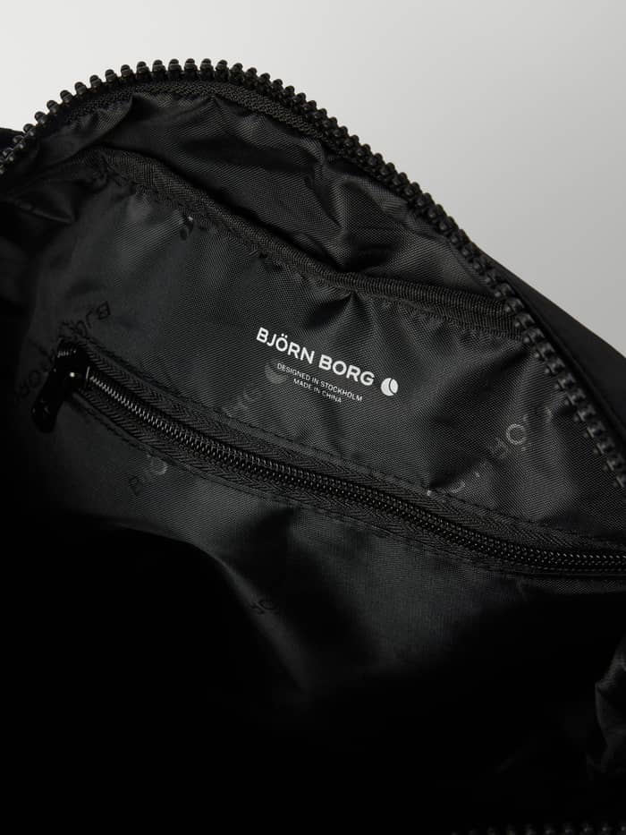Interior view of the Black Beauty (Black) Studio Shoulder Bag 18L with an internal zip pocket for training gear. - Image 4