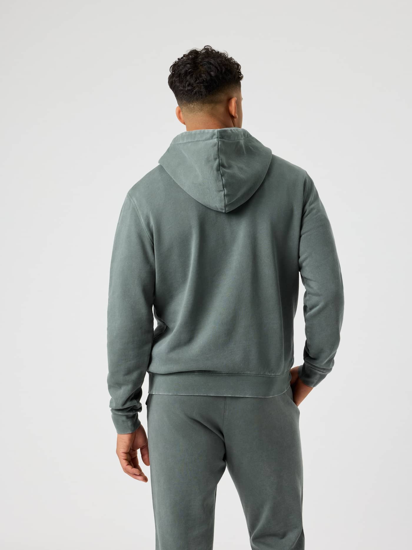 Vue de dos d'un homme en Borg Classic Print Hoodie en coton Urban Chic (Vert), au style tennis fonctionnel hors terrain. - Image 2