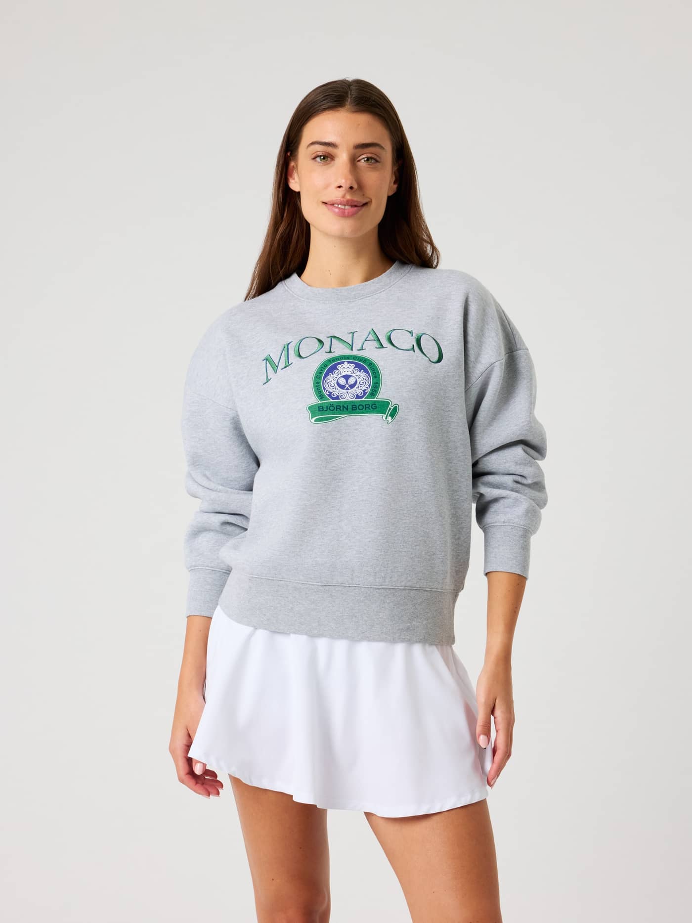 Front view of a woman wearing the oversized Borg Boyfriend Sweatshirt in Light Grey Melange (Grey) with a tennis logo. - Image 2