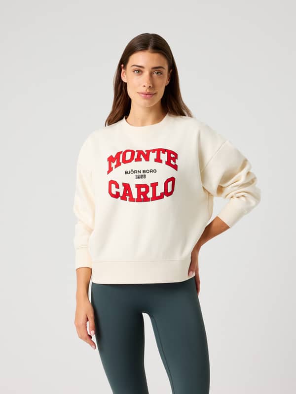 Front view of a woman in the oversized Borg Boyfriend Sweatshirt in Tofu (white) with red Monte Carlo graphics.