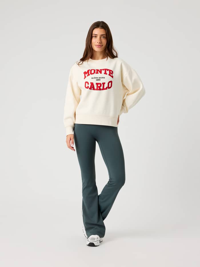 Vorderansicht eines Models im Borg Boyfriend Sweatshirt in Tofu (Weiß) mit rotem Monte-Carlo-Grafikprint und Oversize-Fit. - Image 3