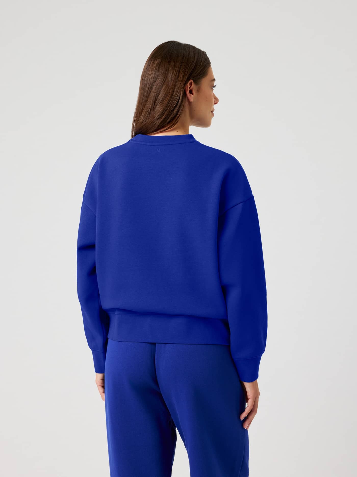 Rückansicht einer Frau im lässigen Borg Boyfriend Sweatshirt in Clematis Blue (Blau) mit oversized Passform. - Image 3