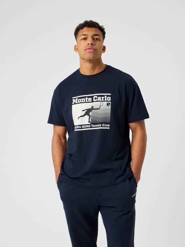 Borg Gym Oversized T-Shirt i Night sky (Marinblå) sedd framifrån med ett vitt Monte Carlo-tennistryck för herrar.