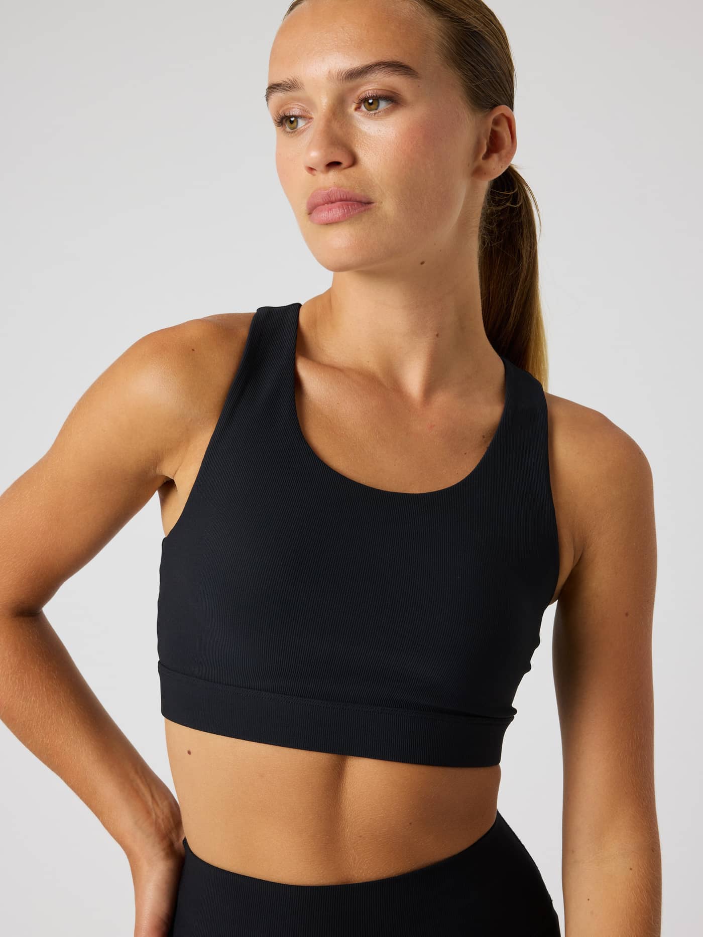 Studio Premium Rib Sports Bra in Black Beauty (Zwart) met een geribde textuur voor training, getoond in vooraanzicht. - Image 6