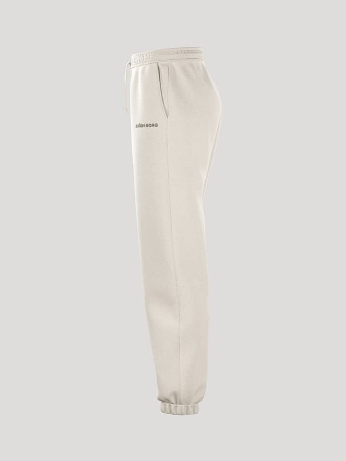 Borg Essential 4 Sweatpants i Tofu (Hvid) set fra siden med en løs pasform, ribkanter og et gråt logo. - Image 4
