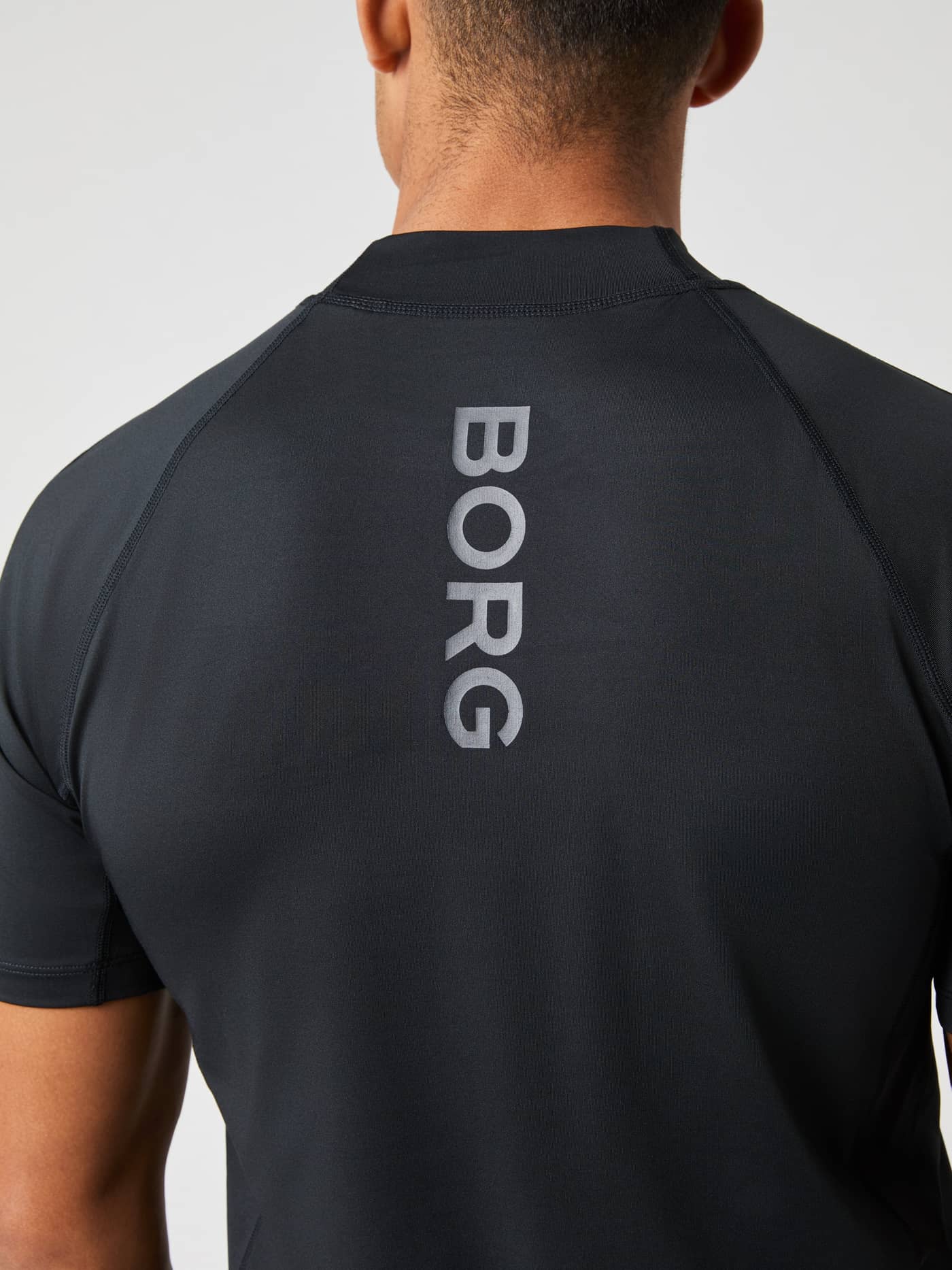 Back view of the men's Borg Mock Neck T-Shirt in Black Beauty (Black) with a vertical grey logo for tennis training. - Image 4