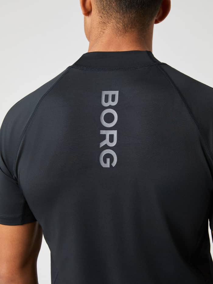 Achteraanzicht van de Borg Mock Neck T-Shirt in Black Beauty (Zwart) met een verticaal grijs logo voor tennistraining. - Image 4
