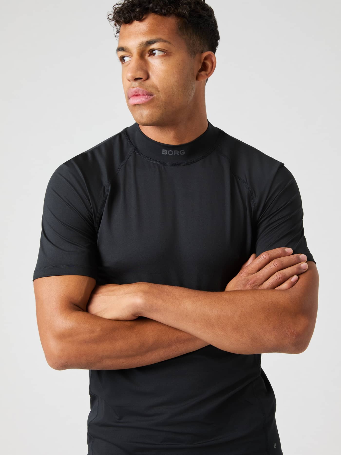 Front view of a man in the functional Borg Mock Neck T-Shirt in Black Beauty (Black) with a grey logo for tennis. - Image 5