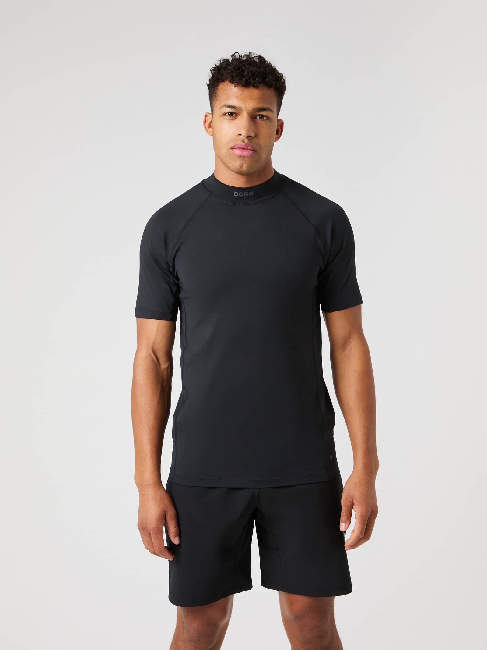 Front view of a man wearing the Borg Mock Neck T-Shirt in Black Beauty (Black), a slim-fit top for training and tennis. - Image 1