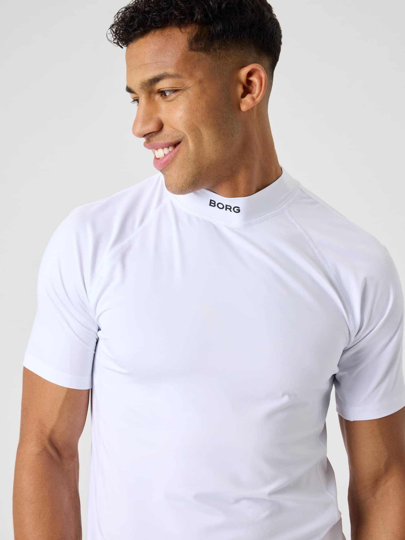 Close-up of the Brilliant White (White) Borg Mock Neck T-Shirt for men, featuring a black BORG logo for tennis and training. - Image 5