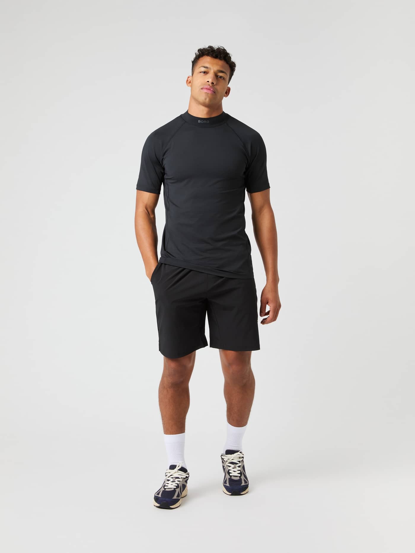 Full-body front view of a man in the slim Björn Borg Mock Neck T-Shirt in Black Beauty (Black) for tennis and training. - Image 3