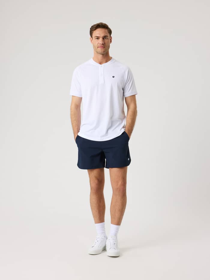 Ganzkörper-Vorderansicht eines Mannes im Brilliant White (Weiß) Ace Sports Polo Shirt für Tennis mit schwarzem Logo. - Image 3
