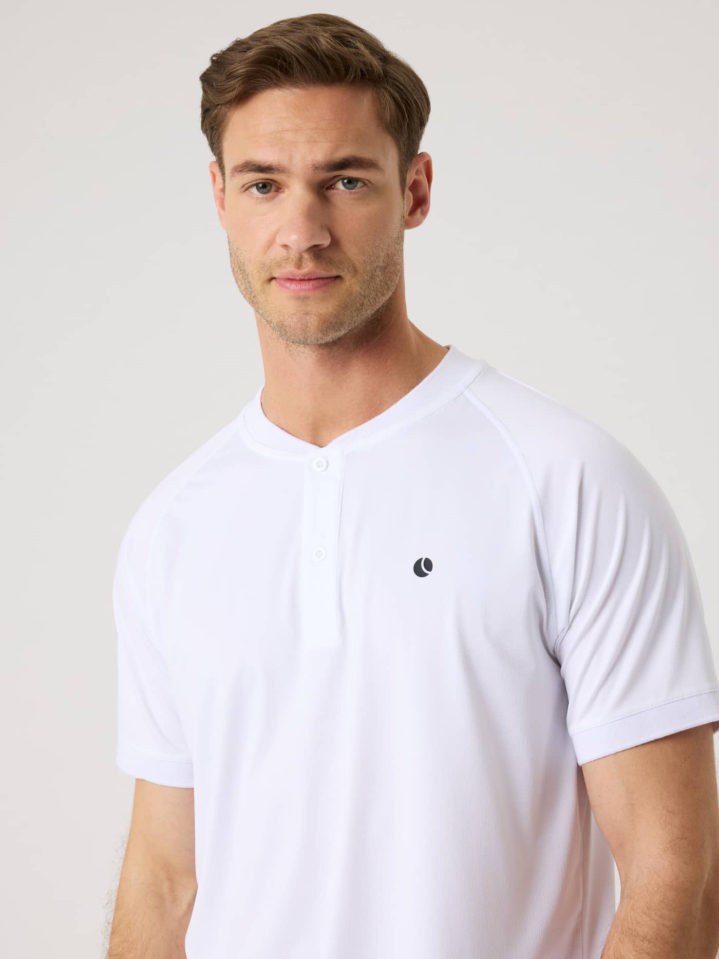 Front view of a man in the Ace Sports Polo Shirt in Brilliant White (White) with a tennis ball print on the chest. - Image 5