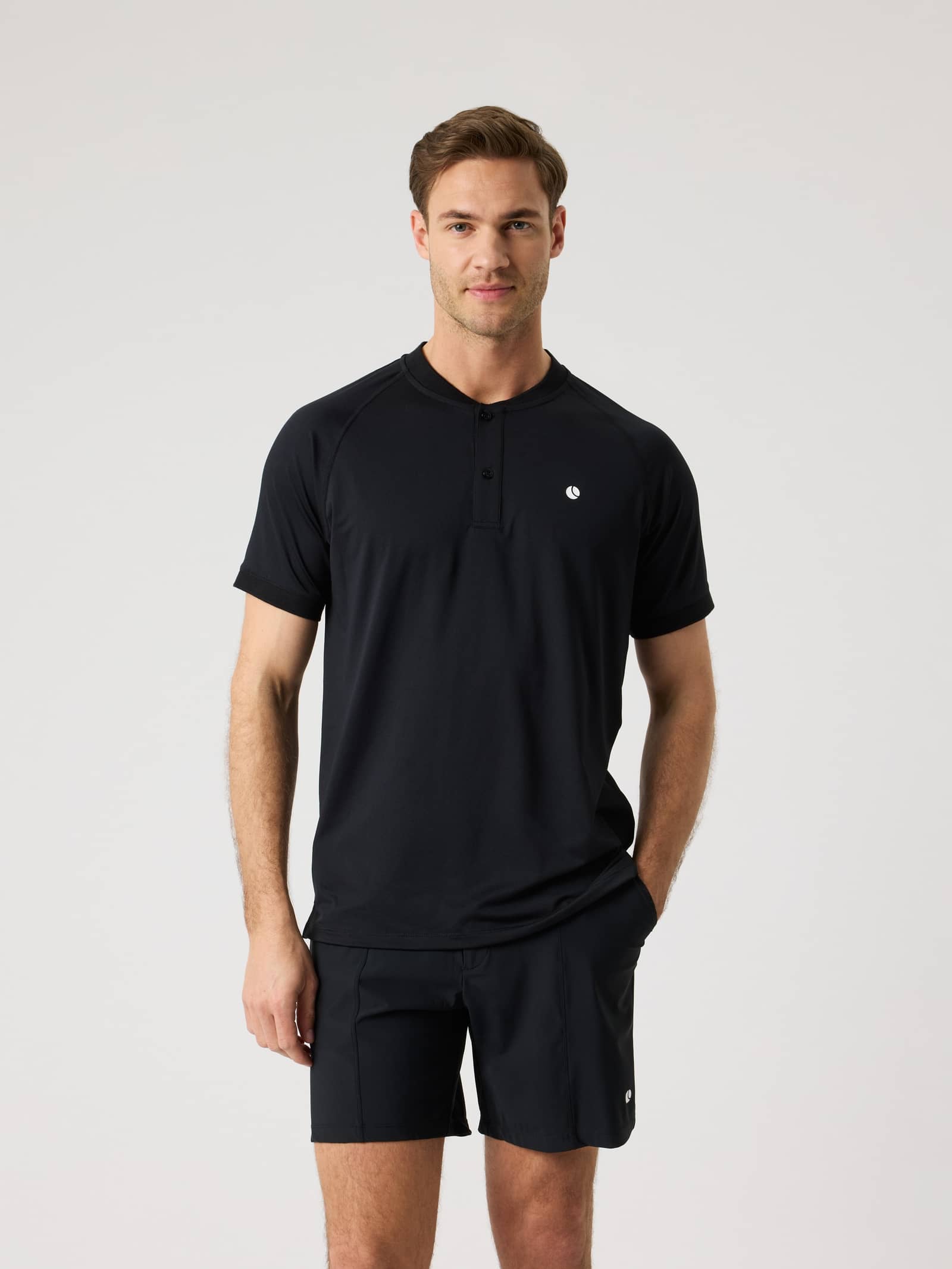 Ace Sports Polo Shirt i Black Beauty (Svart) för herrar sedd framifrån med stretch och vit tennisbollslogga för tennis. - Image 1