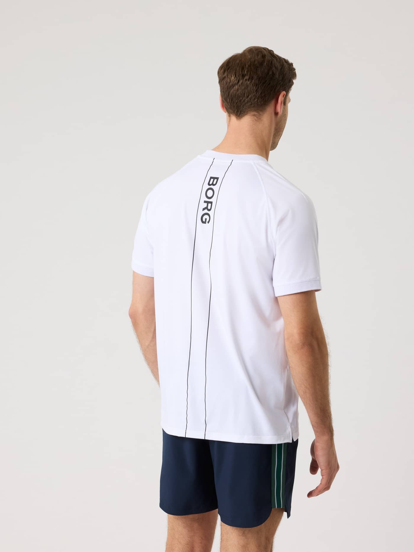 Back view of a man in the Ace Sports Polo Shirt in Brilliant White (White) with a black BORG logo for tennis performance. - Image 2