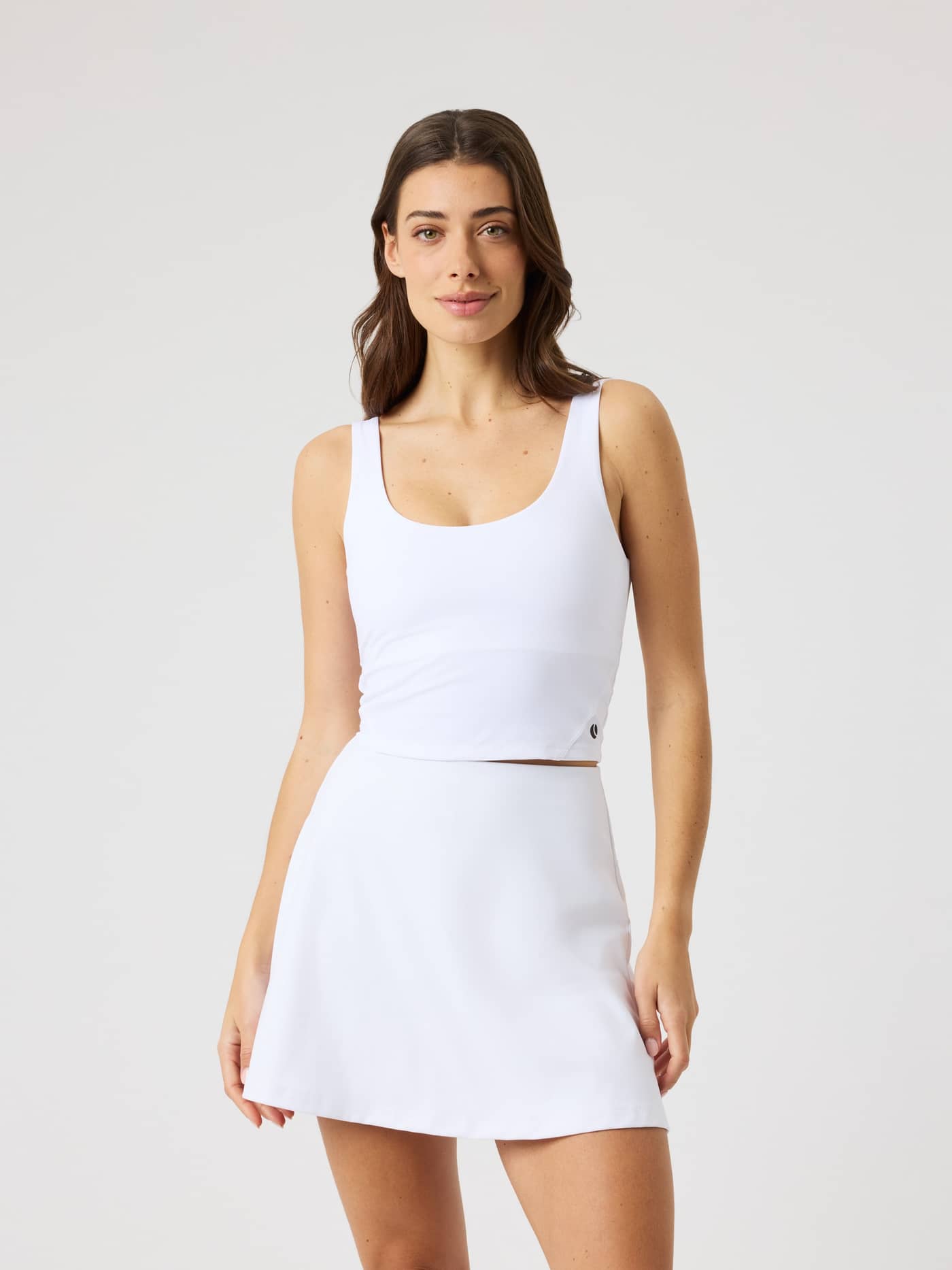 Front view of a woman in the slim-fit Björn Borg Ace 2 In 1 Cropped Tank in Brilliant White (White) for tennis and training. - Image 2