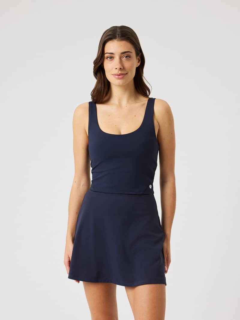 Front view of a woman wearing the Björn Borg Ace 2 In 1 Cropped Tank in Night Sky (Navy), slim fit for tennis performance.