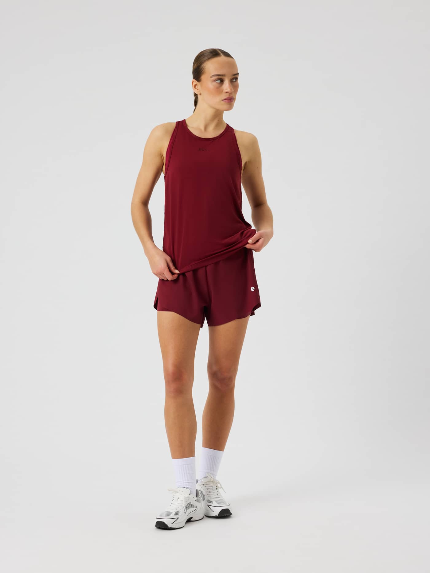 Front view of the Ace 2 In 1 Shorts in Cabernet (red) featuring side slits for tennis and padel play. - Image 1