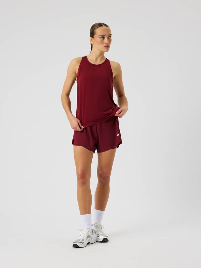 Front view of the Ace 2 In 1 Shorts in Cabernet (red) featuring side slits for tennis and padel play.
