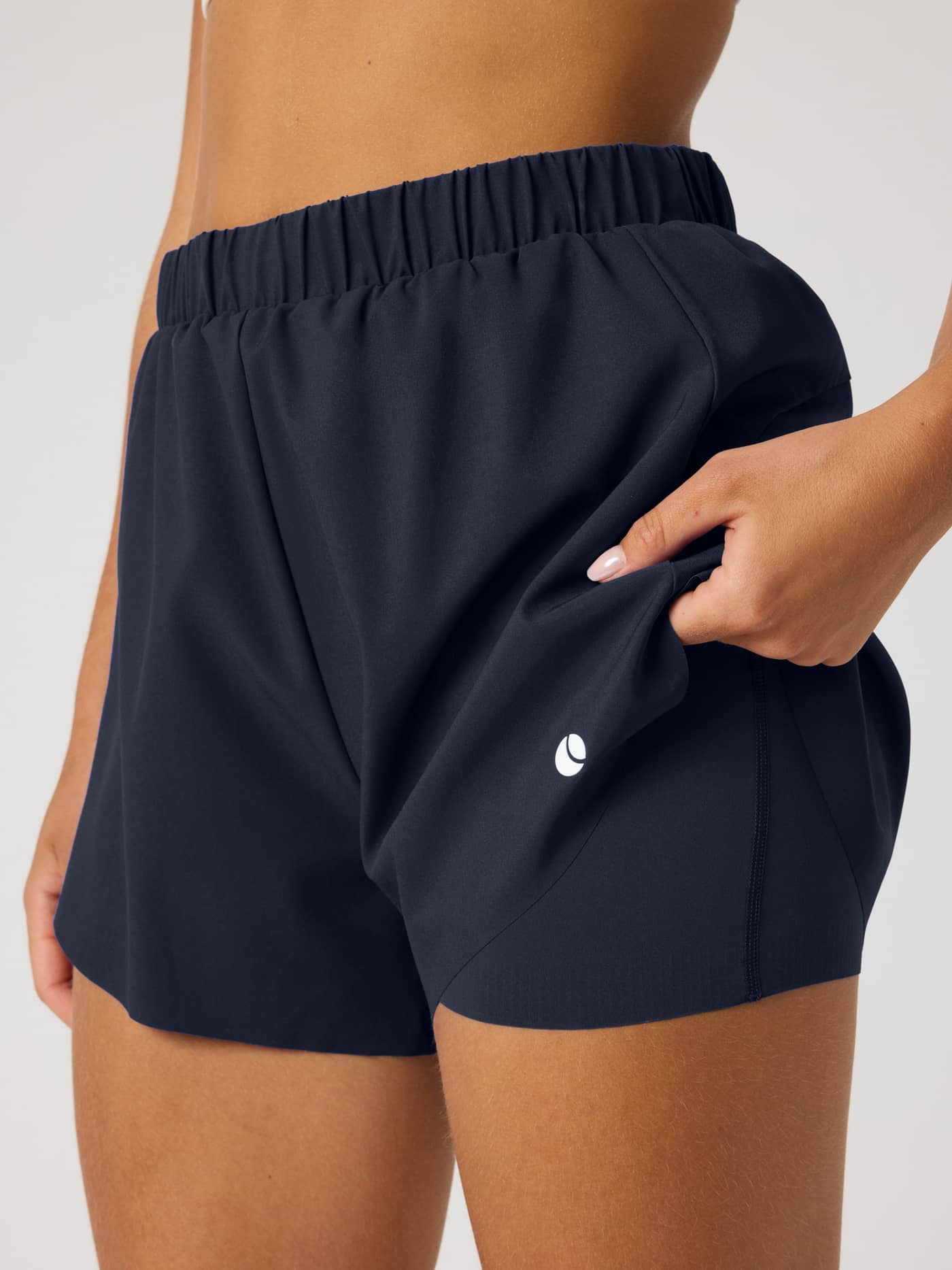 Detailed side view of the Ace 2 In 1 Shorts in Night sky (Navy), showing the performance layer and white logo for tennis. - Image 3