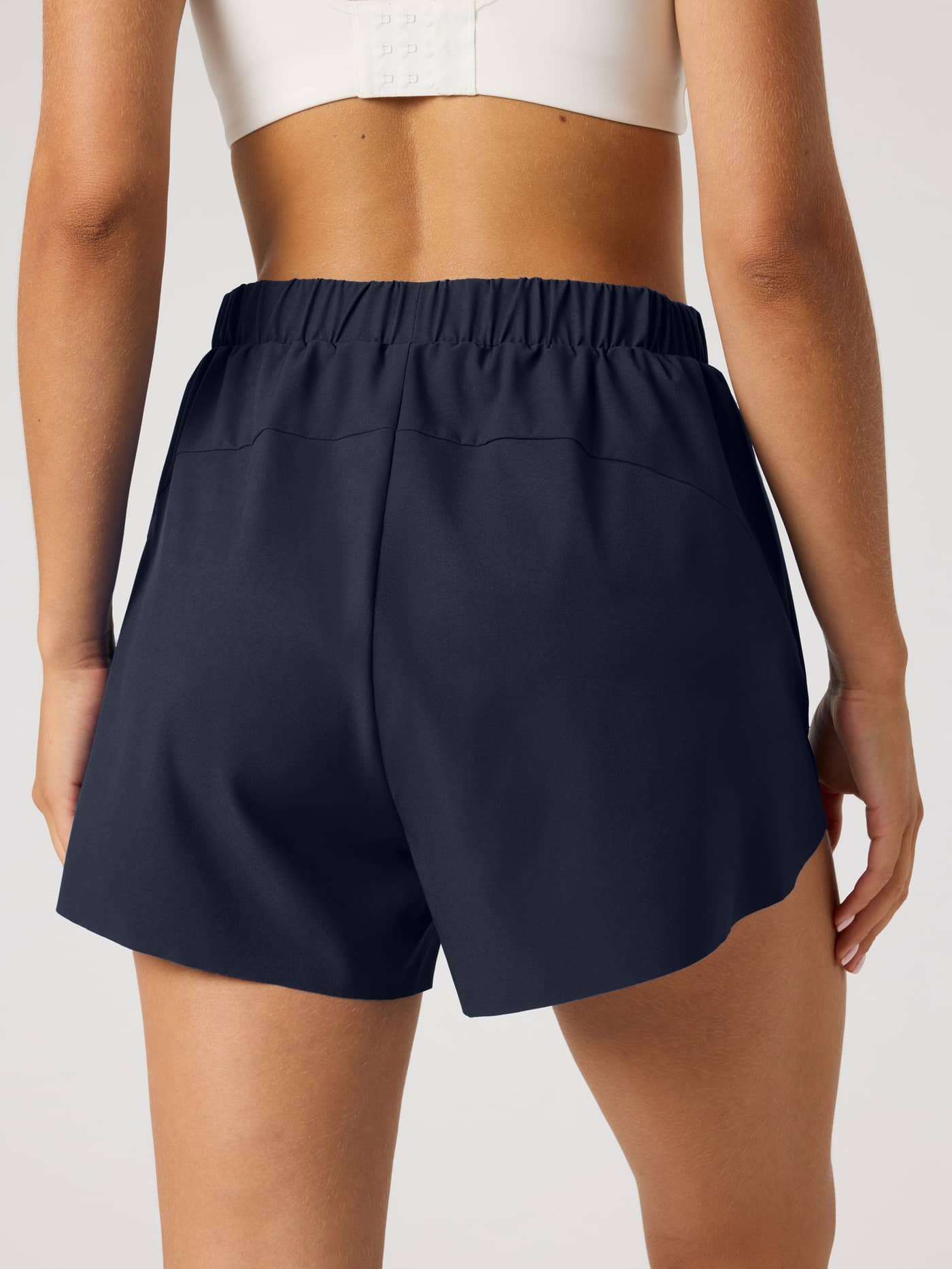 Back view of a model wearing the Ace 2 In 1 Shorts in Night sky (Navy), offering a performance fit for tennis. - Image 2