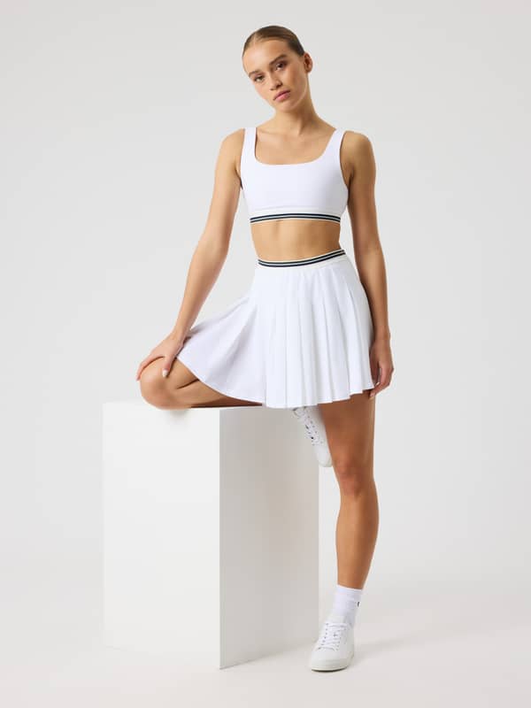 Vue de face de l'Ace Pleated Skirt en Brilliant White (Blanc), jupe de tennis plissée offrant style et performance.