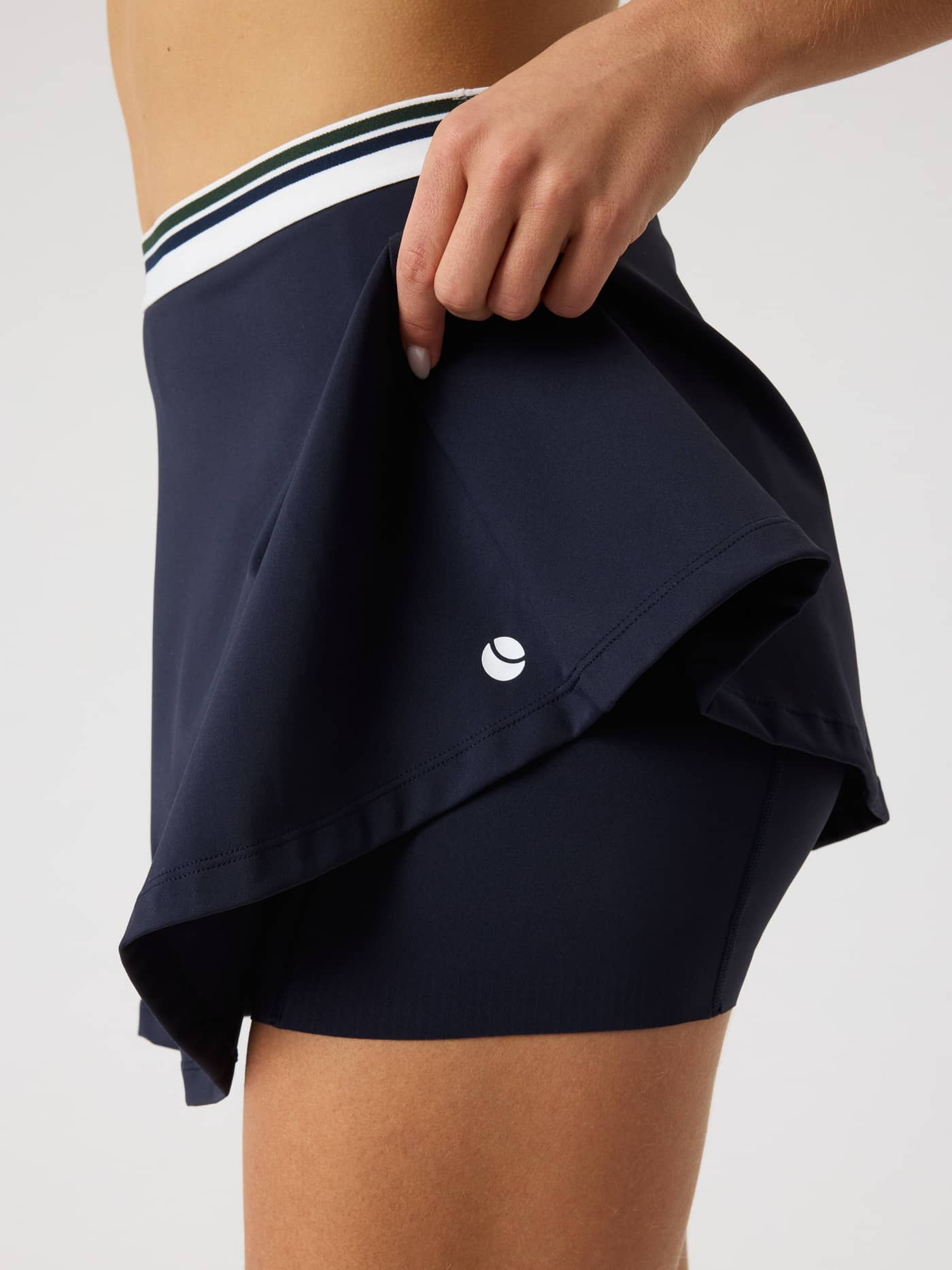 Close-up of the Björn Borg Ace Court Skirt in Night sky (Navy) showing a white logo and integrated inner shorts for tennis. - Image 5