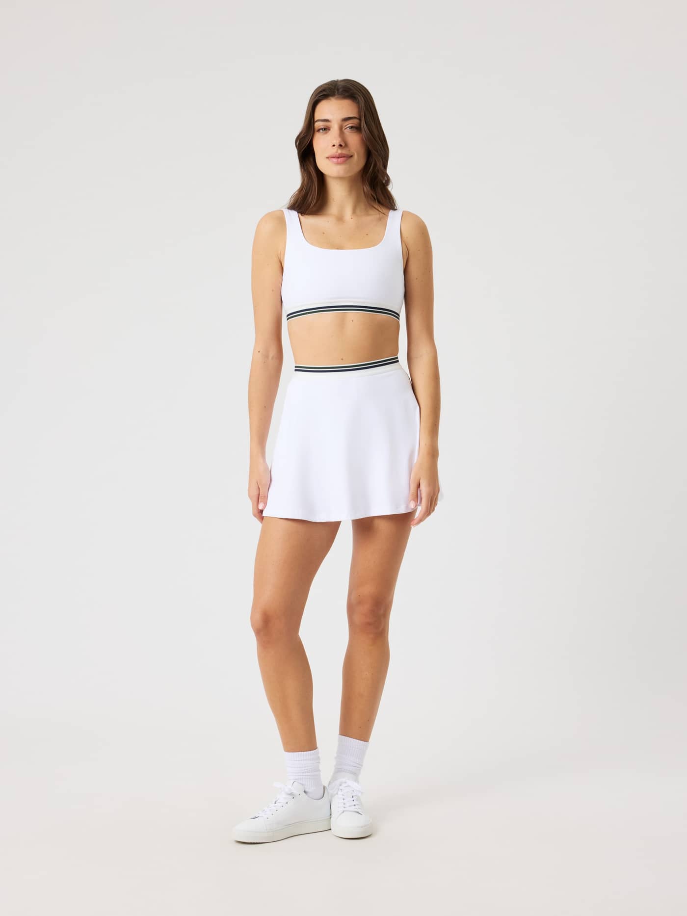 Full-body front view of a model wearing the Björn Borg Ace Court Skirt in Brilliant White (White) for a stylish tennis fit. - Image 3