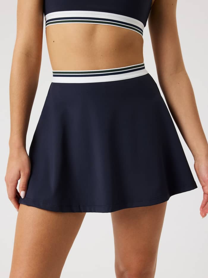 Ace Court Skirt in Night sky (Marineblauw), stijlvolle performance tennisrok in vooraanzicht met gestreepte tailleband.