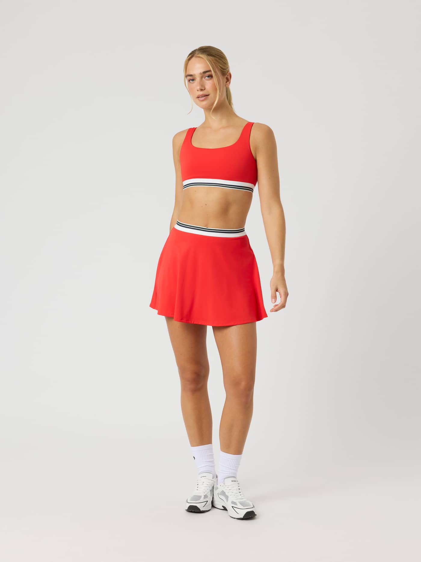 Ace Court Top i Flame Scarlet (Rød) sett forfra på en modell i full lengde til tennis og padel. - Image 4