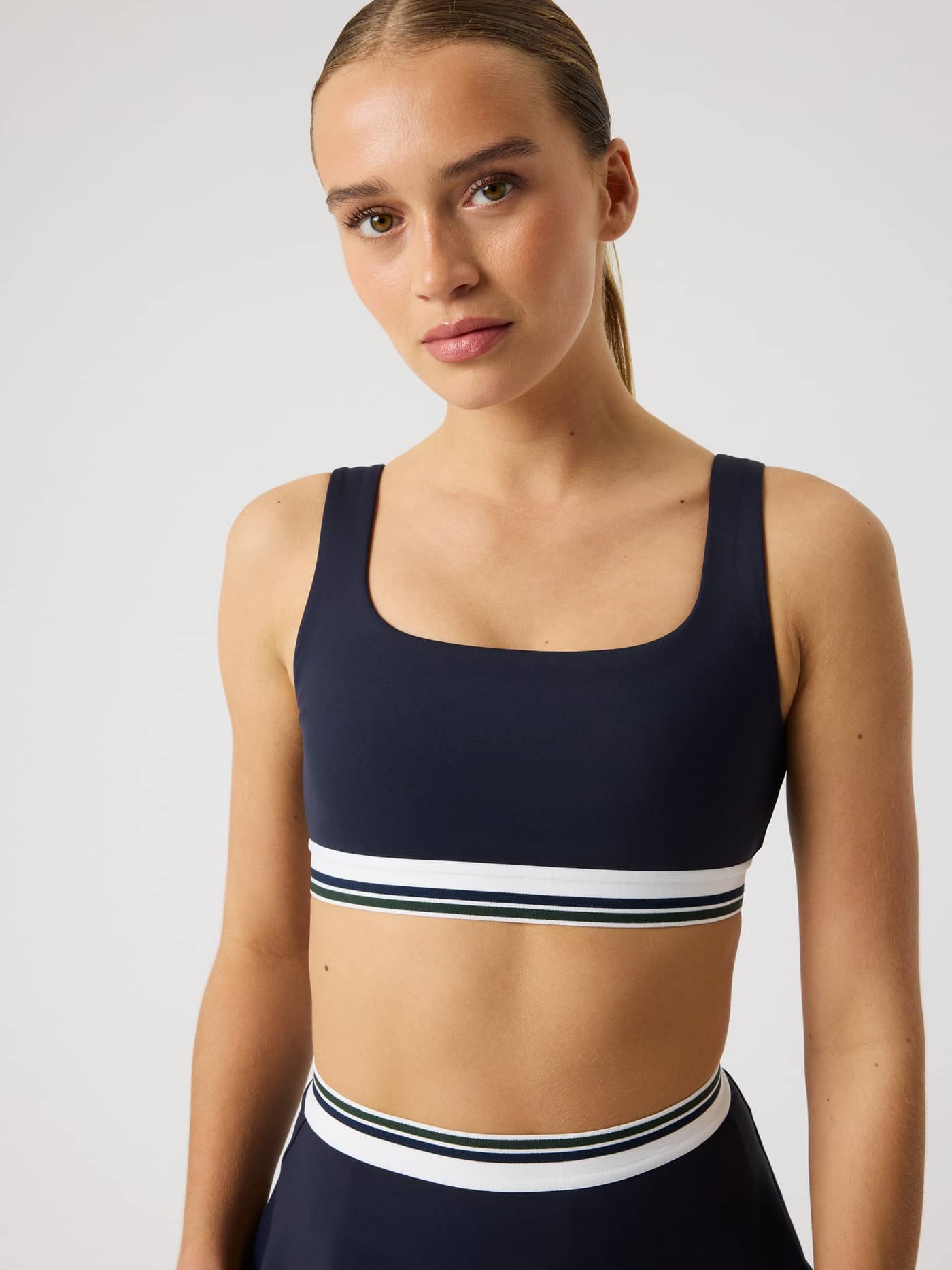 Front view of a model in the Night sky (Navy) Björn Borg Ace Court Top with a striped waistband for a stylish tennis fit. - Image 5