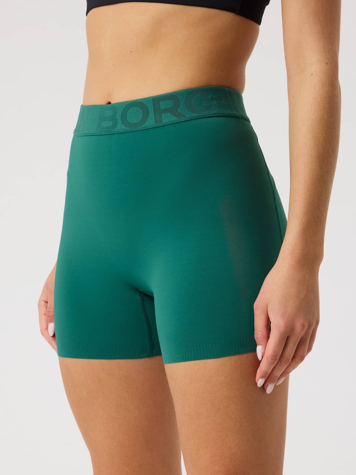 Närbild på följsamma Borg Short Tights i Posy Green (Grön) med märkt elastisk midjeresår för träning. - Image 1