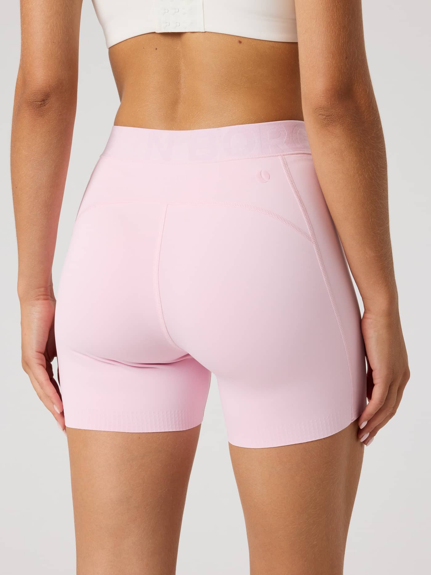 Rückansicht eines Models in den Borg Short Tights in Pink Lady (Rosa) mit stylischer Passform für Tennis und Training. - Image 2