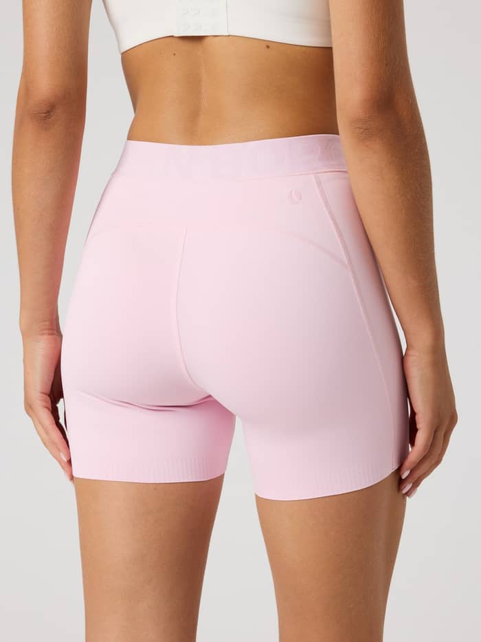 Back view of a model wearing the Borg Short Tights in Pink Lady (Pink), offering a stylish fit for tennis and training. - Image 2