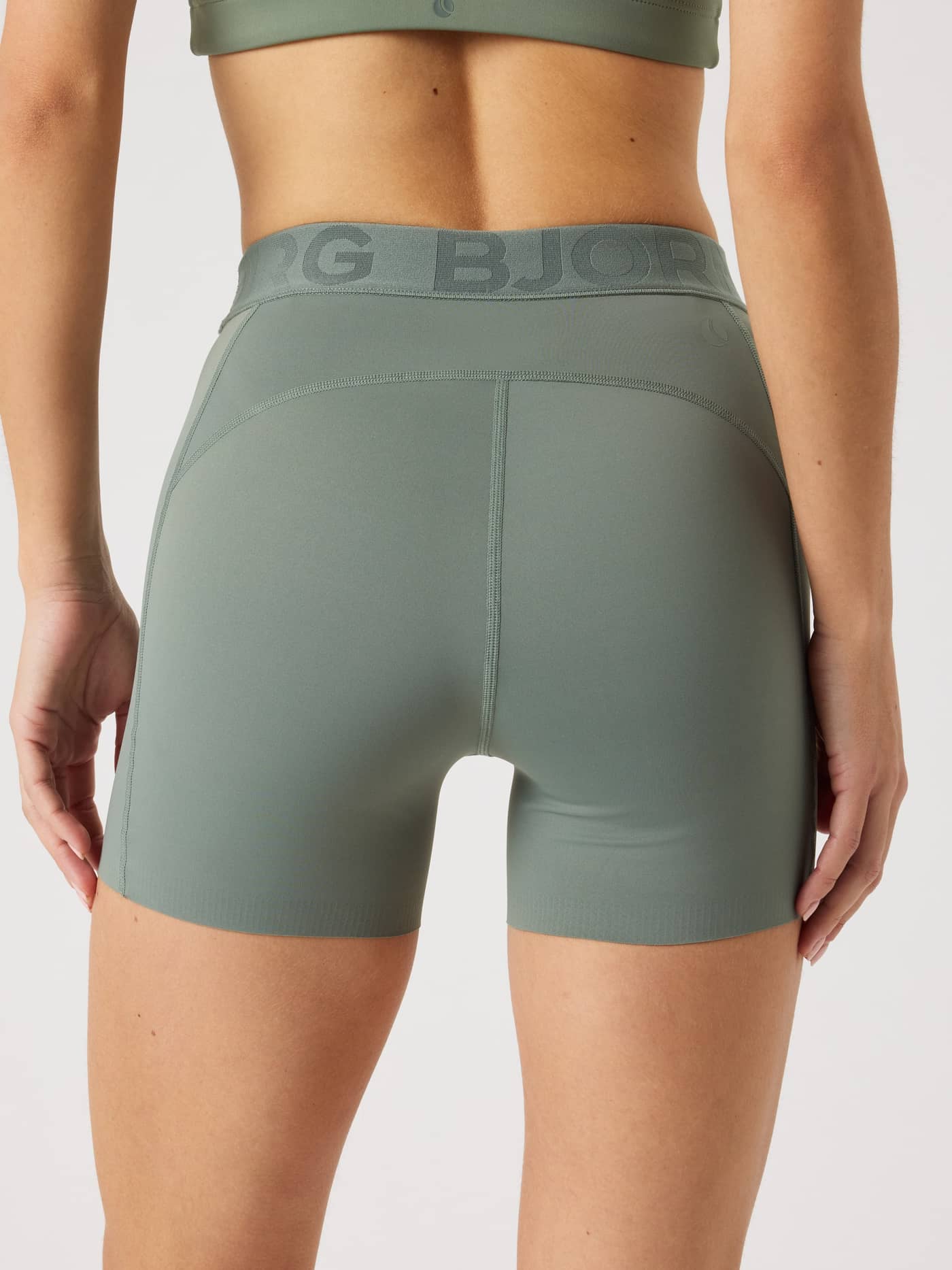 Back view of a model wearing the Agave Green (Green) Borg Short Tights, designed for training and tennis. - Image 2