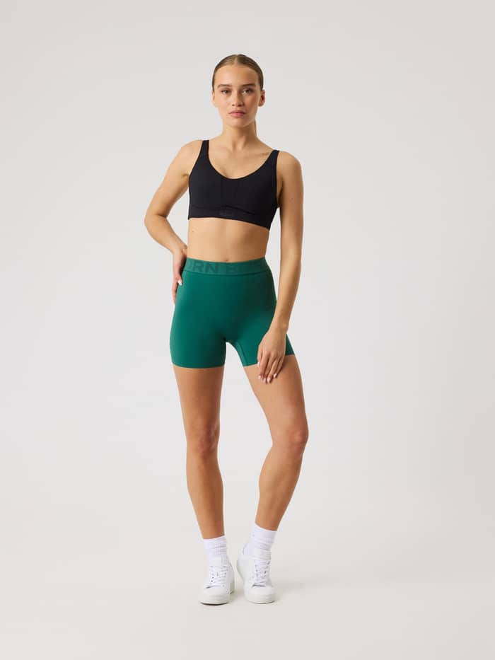 Full-body front view of a woman in Posy Green (Green) Borg Short Tights, offering a flattering fit for training. - Image 3