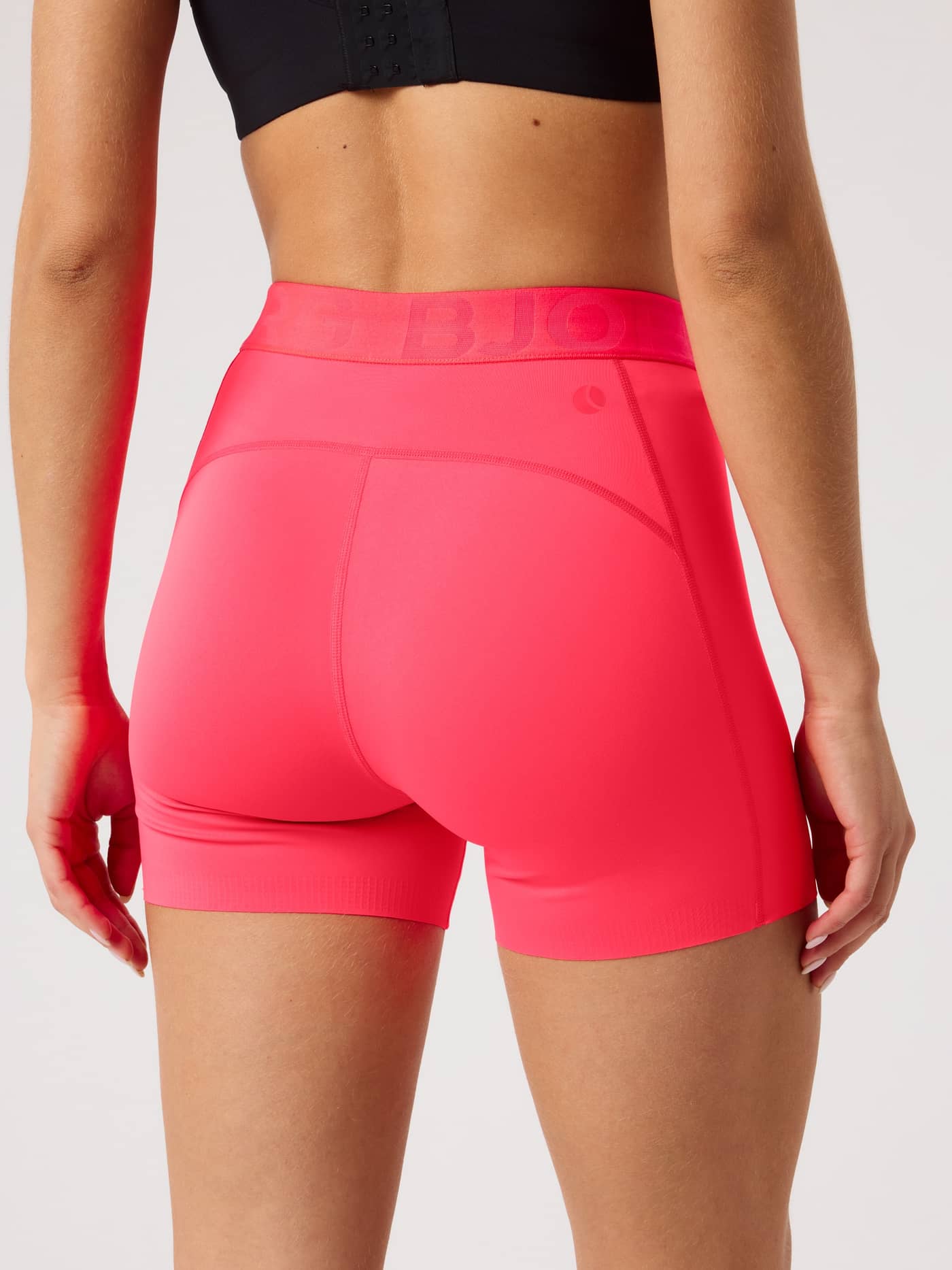 Back view of a model wearing the form-fitting Borg Short Tights in Diva Pink (Pink) for training and tennis. - Image 2