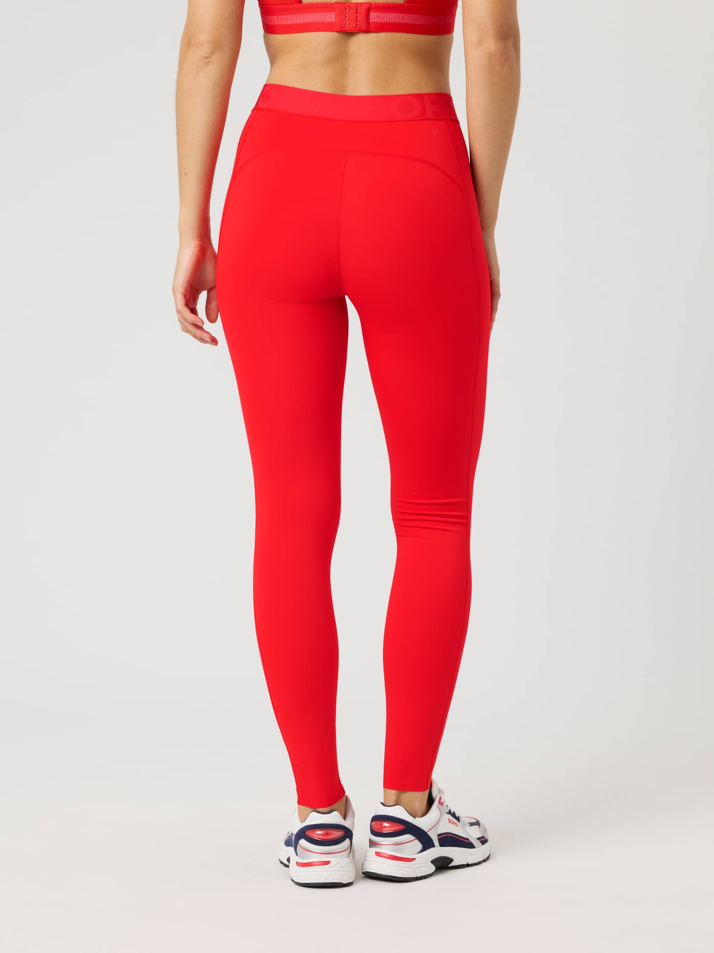 Back view of a woman wearing Borg Tights in Flame Scarlet (Red) with a slim fit for training, running, and tennis. - Image 2