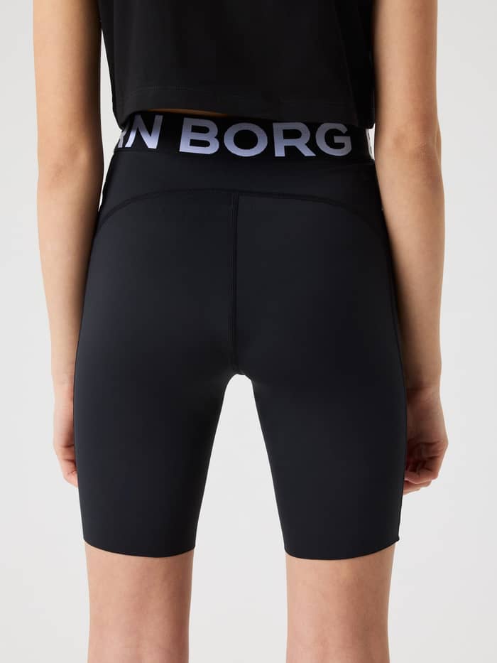 Back view of a model wearing kids training and running Borg Short Tights in Black Beauty (Black) with a branded waistband. - Image 2