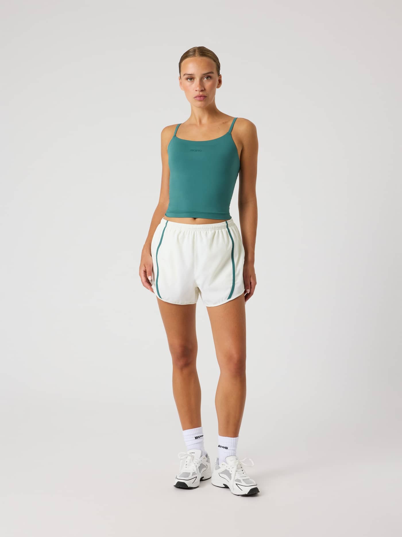 Full-body front view of a woman in the Borg Sports Shorts in Tofu (White), providing a stylish fit for training and tennis. - Image 3