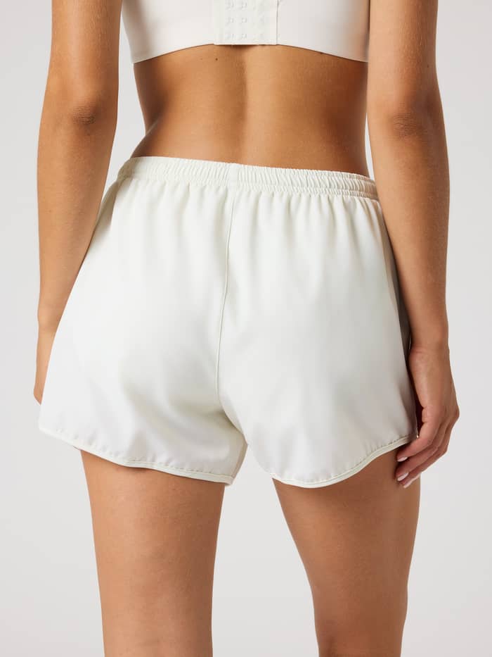 Back view of a woman wearing the Tofu (White) Borg Sports Shorts, a regular fit style for gym and tennis training. - Image 2