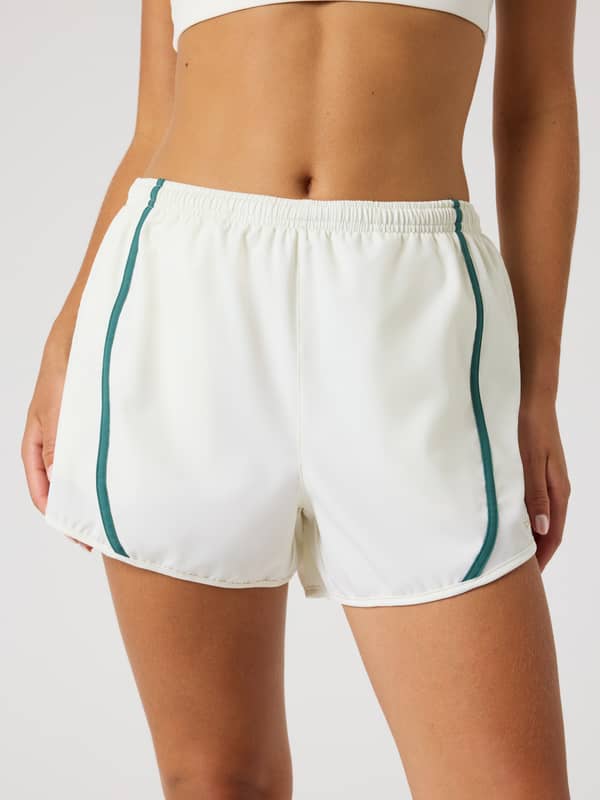 Vue de face d'un mannequin en Borg Sports Shorts Tofu (Blanc) avec liseré vert et coupe régulière pour l'entraînement.