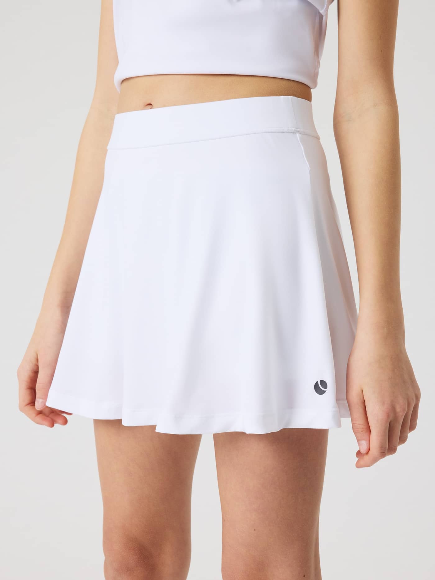 Sett forfra av modell i kids Ace Jersey Skirt i ribbjersey, Brilliant White (Hvit) for tennistrening og ytelse. - Image 2
