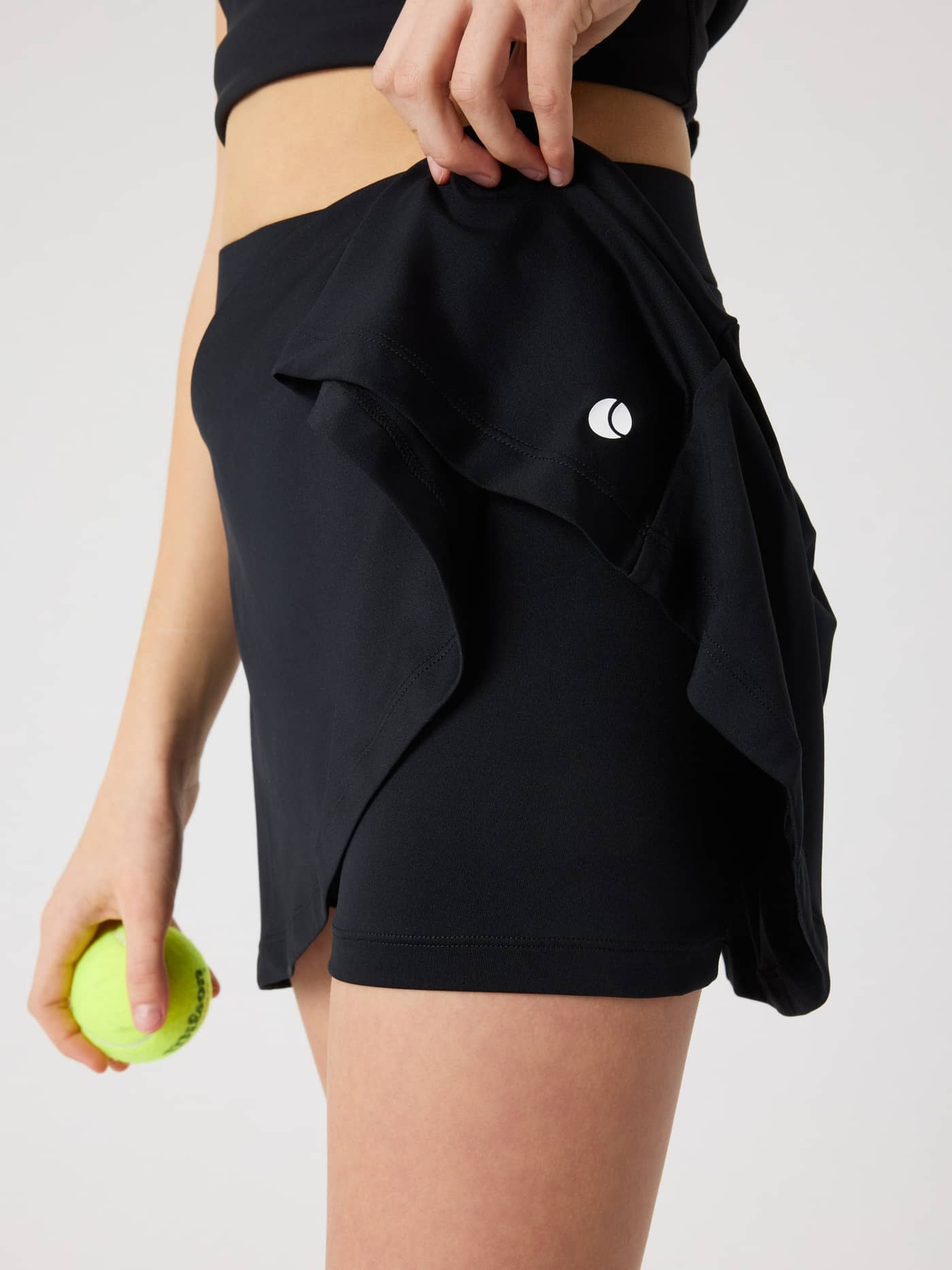 Ace Jersey Skirt for kids in Black Beauty (Black), showing the soft rib jersey and inner tennis shorts with ball logo. - Image 3