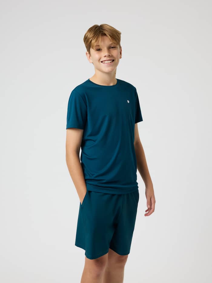 Front view of a model in the kids Björn Borg Ace Light T-Shirt in Reflecting Pond (Green), designed for tennis.