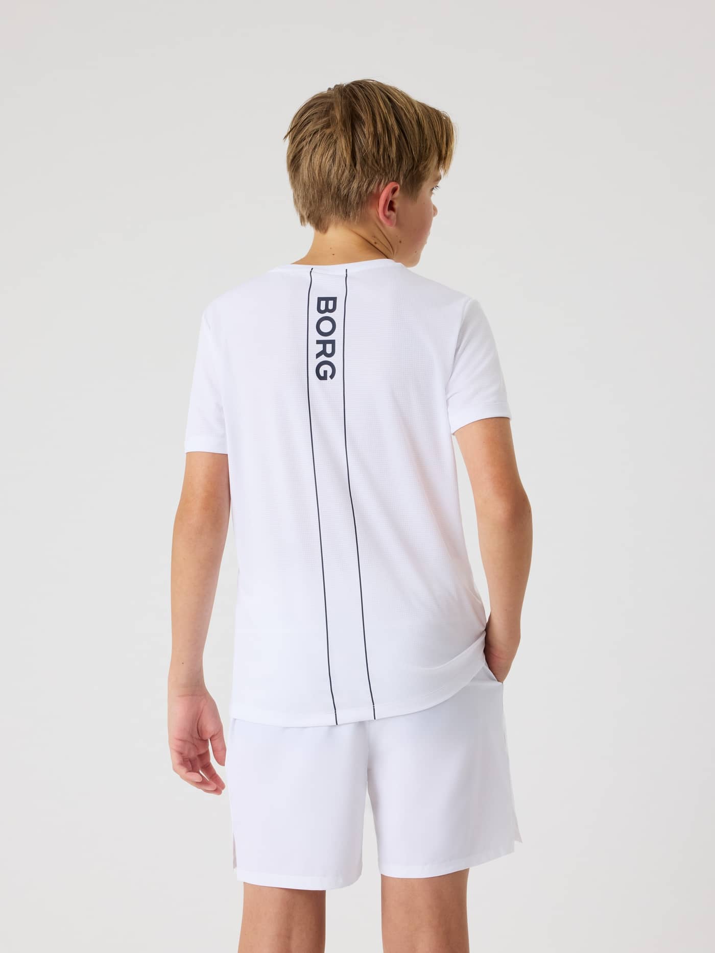 Rückansicht eines Kids im Ace Light T-Shirt in Brilliant White (Weiß) mit navyfarbenem Logo für das Tennis-Training. - Image 4